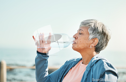 Image of Senior woman, drinking water and health with fitness, hydration and break during workout outdoor. Plastic bottle, liquid and wellness with female athlete at the beach, exercise and training with h2o