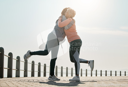 Image of Running, hug and women by sea and ocean with love and care for fitness and exercise. Athlete, wellness and female friends on a beach promenade with motivation, embrace and smile from runner target