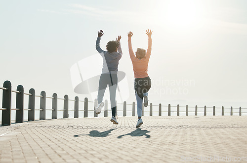 Image of Fitness, jump and freedom with friends at beach for celebration, motivation and training. Cardio, workout and health with mature women in nature for running, energy and exercise goals together