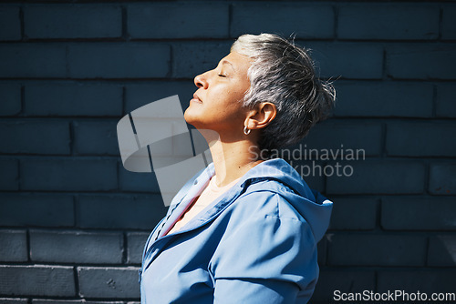 Image of Senior woman, fitness and thinking with sunshine, vitamin d and relax outdoor at training, exercise or workout. Mature runner lady, sunbathing and city with mindset, peace and commitment to health