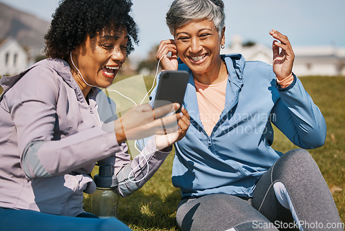 Image of Senior woman, daughter and outdoor phone call or listening to news, announcement or social media, blog or podcast about workout. Elderly mother, girl and share earphones together on screen