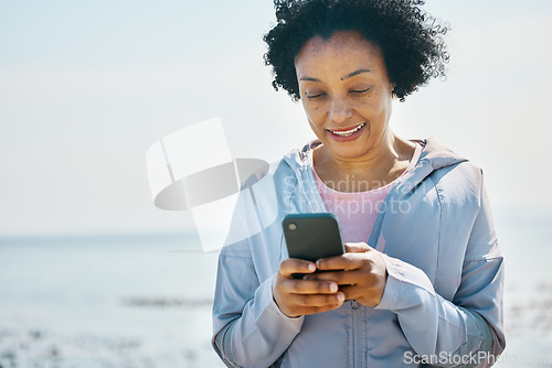 Image of Fitness, beach and senior woman with smartphone, typing and social media with connection, network and smile. Happy person, pensioner and old lady with a cellphone, happiness and contact with message