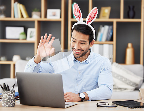 Image of Businessman, bunny ears and video call at home in online meeting with computer screen and wave greeting. Remote work, holiday and rabbit costume for digital education class with male teacher at house