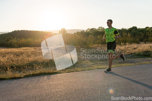 Image of Triathlete in professional gear running early in the morning, preparing for a marathon, dedication to sport and readiness to take on the challenges of a marathon.