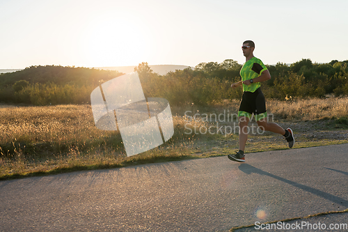 Image of Triathlete in professional gear running early in the morning, preparing for a marathon, dedication to sport and readiness to take on the challenges of a marathon.