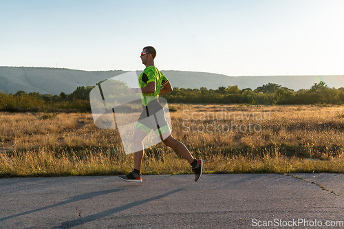 Image of Triathlete in professional gear running early in the morning, preparing for a marathon, dedication to sport and readiness to take on the challenges of a marathon.