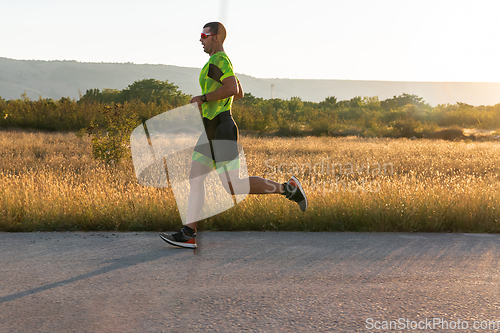 Image of Triathlete in professional gear running early in the morning, preparing for a marathon, dedication to sport and readiness to take on the challenges of a marathon.