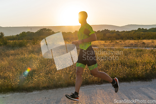 Image of Triathlete in professional gear running early in the morning, preparing for a marathon, dedication to sport and readiness to take on the challenges of a marathon.