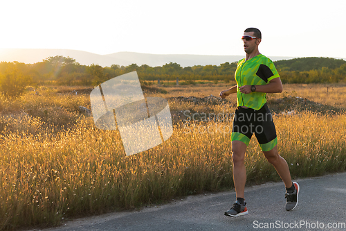 Image of Triathlete in professional gear running early in the morning, preparing for a marathon, dedication to sport and readiness to take on the challenges of a marathon.