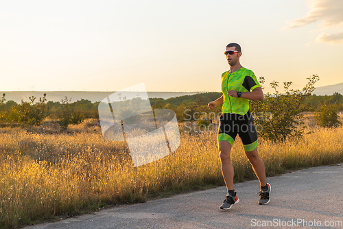 Image of Triathlete in professional gear running early in the morning, preparing for a marathon, dedication to sport and readiness to take on the challenges of a marathon.