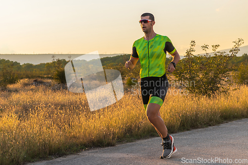 Image of Triathlete in professional gear running early in the morning, preparing for a marathon, dedication to sport and readiness to take on the challenges of a marathon.