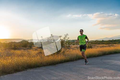 Image of Triathlete in professional gear running early in the morning, preparing for a marathon, dedication to sport and readiness to take on the challenges of a marathon.