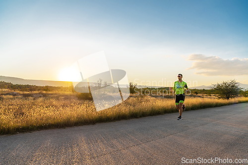 Image of Triathlete in professional gear running early in the morning, preparing for a marathon, dedication to sport and readiness to take on the challenges of a marathon.