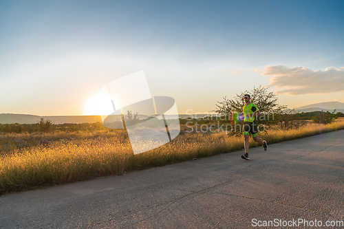 Image of Triathlete in professional gear running early in the morning, preparing for a marathon, dedication to sport and readiness to take on the challenges of a marathon.