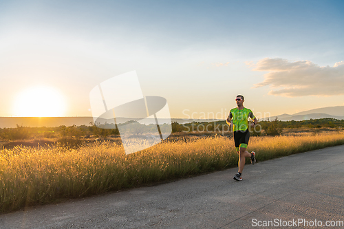 Image of Triathlete in professional gear running early in the morning, preparing for a marathon, dedication to sport and readiness to take on the challenges of a marathon.