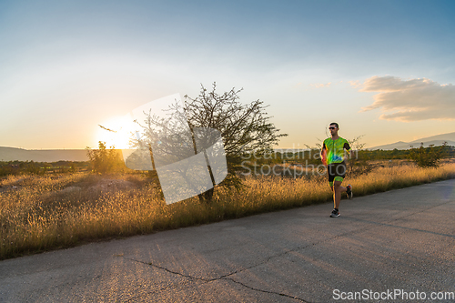 Image of Triathlete in professional gear running early in the morning, preparing for a marathon, dedication to sport and readiness to take on the challenges of a marathon.