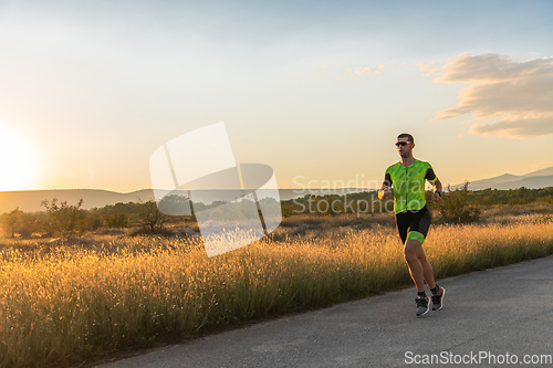 Image of Triathlete in professional gear running early in the morning, preparing for a marathon, dedication to sport and readiness to take on the challenges of a marathon.
