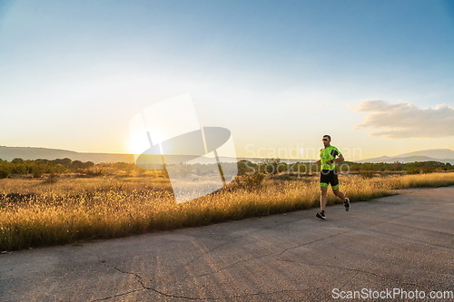 Image of Triathlete in professional gear running early in the morning, preparing for a marathon, dedication to sport and readiness to take on the challenges of a marathon.