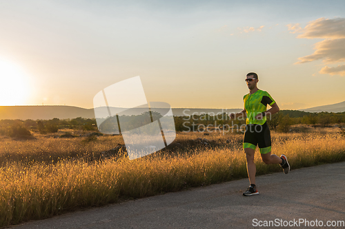 Image of Triathlete in professional gear running early in the morning, preparing for a marathon, dedication to sport and readiness to take on the challenges of a marathon.