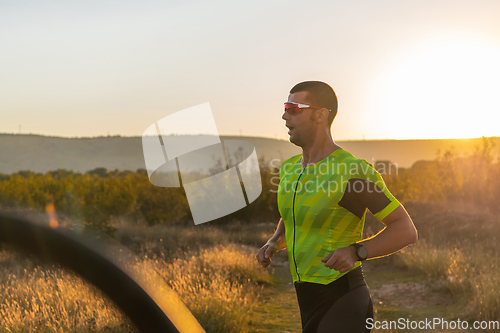 Image of Triathlete in professional gear running early in the morning, preparing for a marathon, dedication to sport and readiness to take on the challenges of a marathon.