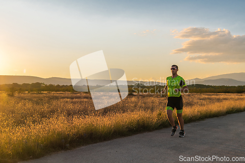 Image of Triathlete in professional gear running early in the morning, preparing for a marathon, dedication to sport and readiness to take on the challenges of a marathon.