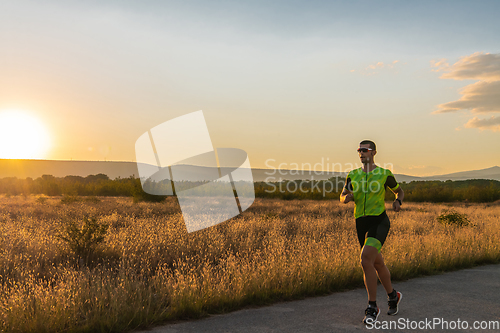 Image of Triathlete in professional gear running early in the morning, preparing for a marathon, dedication to sport and readiness to take on the challenges of a marathon.