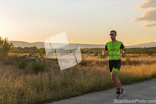 Image of Triathlete in professional gear running early in the morning, preparing for a marathon, dedication to sport and readiness to take on the challenges of a marathon.