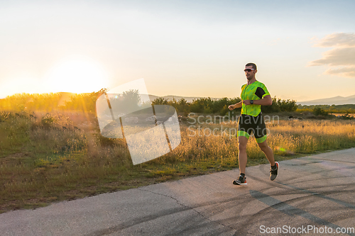 Image of Triathlete in professional gear running early in the morning, preparing for a marathon, dedication to sport and readiness to take on the challenges of a marathon.