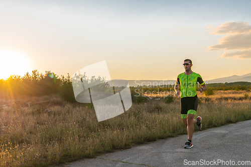 Image of Triathlete in professional gear running early in the morning, preparing for a marathon, dedication to sport and readiness to take on the challenges of a marathon.