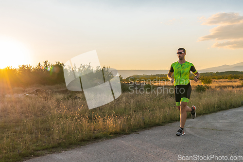 Image of Triathlete in professional gear running early in the morning, preparing for a marathon, dedication to sport and readiness to take on the challenges of a marathon.