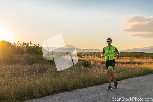 Image of Triathlete in professional gear running early in the morning, preparing for a marathon, dedication to sport and readiness to take on the challenges of a marathon.