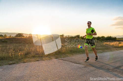 Image of Triathlete in professional gear running early in the morning, preparing for a marathon, dedication to sport and readiness to take on the challenges of a marathon.