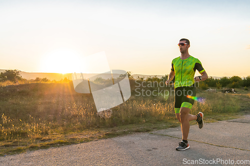 Image of Triathlete in professional gear running early in the morning, preparing for a marathon, dedication to sport and readiness to take on the challenges of a marathon.