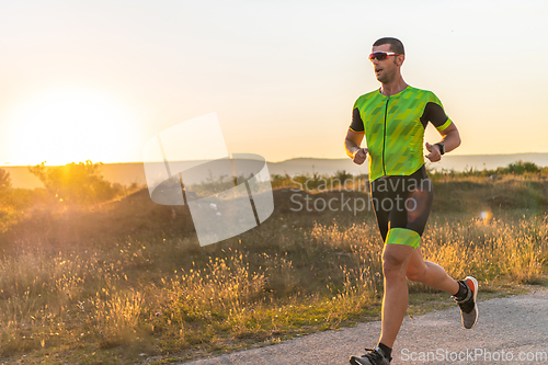 Image of Triathlete in professional gear running early in the morning, preparing for a marathon, dedication to sport and readiness to take on the challenges of a marathon.