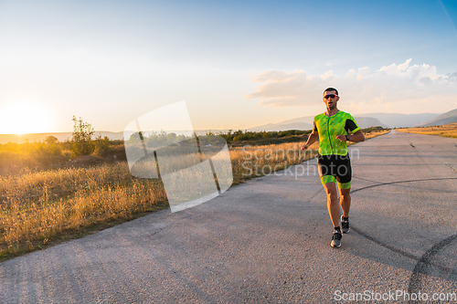 Image of Triathlete in professional gear running early in the morning, preparing for a marathon, dedication to sport and readiness to take on the challenges of a marathon.