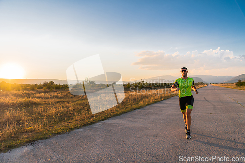 Image of Triathlete in professional gear running early in the morning, preparing for a marathon, dedication to sport and readiness to take on the challenges of a marathon.