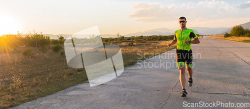 Image of Triathlete in professional gear running early in the morning, preparing for a marathon, dedication to sport and readiness to take on the challenges of a marathon.