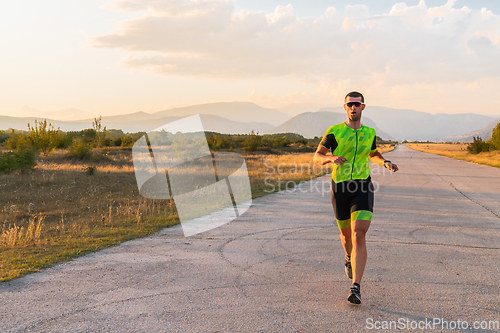 Image of Triathlete in professional gear running early in the morning, preparing for a marathon, dedication to sport and readiness to take on the challenges of a marathon.