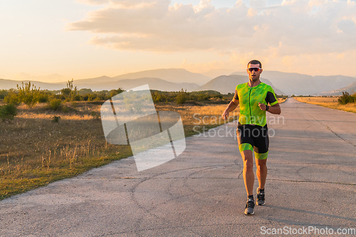 Image of Triathlete in professional gear running early in the morning, preparing for a marathon, dedication to sport and readiness to take on the challenges of a marathon.