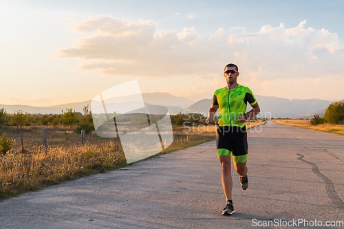 Image of Triathlete in professional gear running early in the morning, preparing for a marathon, dedication to sport and readiness to take on the challenges of a marathon.