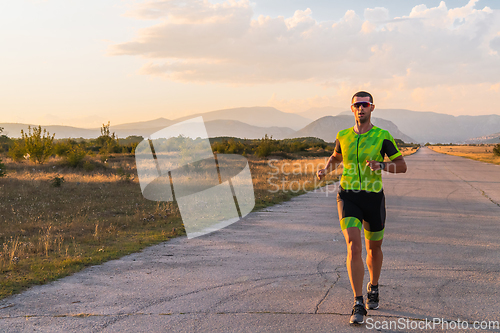 Image of Triathlete in professional gear running early in the morning, preparing for a marathon, dedication to sport and readiness to take on the challenges of a marathon.