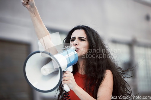 Image of Megaphone, woman and shouting for social change, justice for equality and humanity with activist on street, stand up and strike. Young female, protester and girl with bullhorn, protesting for freedom