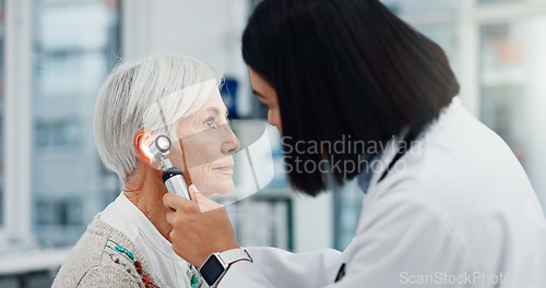 Image of Senior woman, doctor and otoscope for ear, hearing test and exam, audio check or consultation for healthcare. Ent, otolaryngology and medical professional with elderly person for wellness in hospital