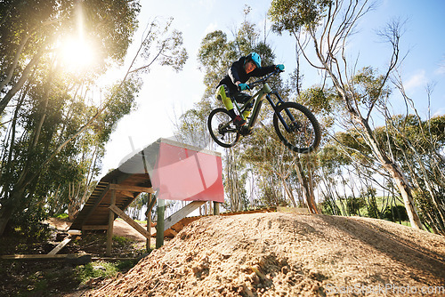 Image of Bike, jump and man with ramp, outdoor and speed for sports, race or adventure in summer, woods or nature. Extreme cycling, person and training on trail, competition or challenge for fitness in forest