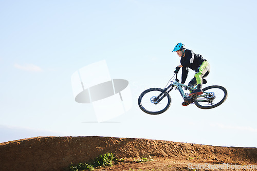 Image of Cycling, sports and man jump with bicycle for adrenaline on adventure, freedom and in air for speed. Mountain bike, tricks and cyclist for training, exercise and fitness on dirt road, trail and track