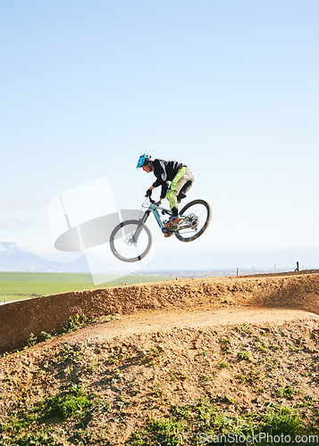 Image of Cycling, sports and man in air on bicycle for adrenaline on adventure, freedom and jump for speed. Mountain bike, tricks and cyclist for training, exercise and fitness on dirt road, trail or track