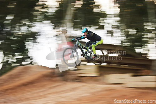 Image of Cycling, sports and person with blur on bicycle for adrenaline on adventure, freedom and speed. Mountain bike action, fast and cyclist for training, exercise and fitness on dirt road, trail and track