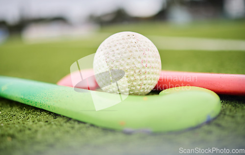 Image of Hockey, stick and ball on a field for a game, training or exercise for sports. Closeup, ground and gear or equipment for fitness, challenge or a competition on the grass of a park for action