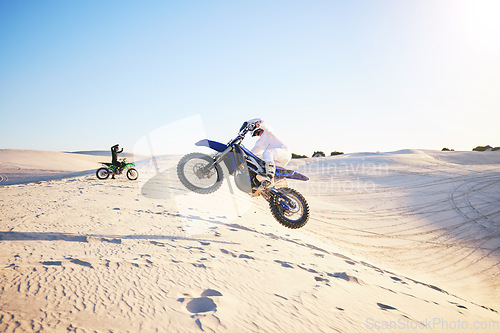 Image of Motorcycle, desert race and jump in air for competition, stunt and outdoor for performance, goal and speed. Motorbike athlete, dunes and ramp in nature, sand and together for training in mockup space