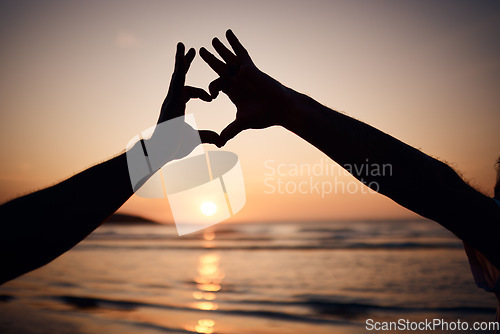 Image of Beach silhouette, sunset and person with heart hands for nature love, trust and outdoor freedom on ocean vacation. Dark shadow, emoji health icon and tourist with wellness, tropical holiday or travel